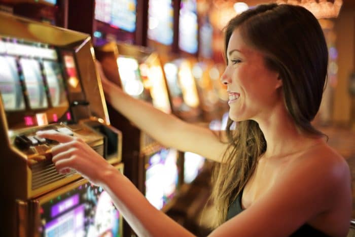 Woman playing slot machine at Casino